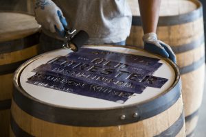 Painting the Old Forester mark on a barrel head