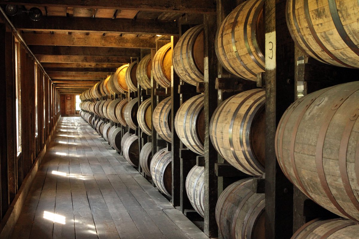 Cooperage: a long view of bourbon barrels stacked in a barn