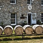 bourbon academy: rail with barrels on it in front of a stone building
