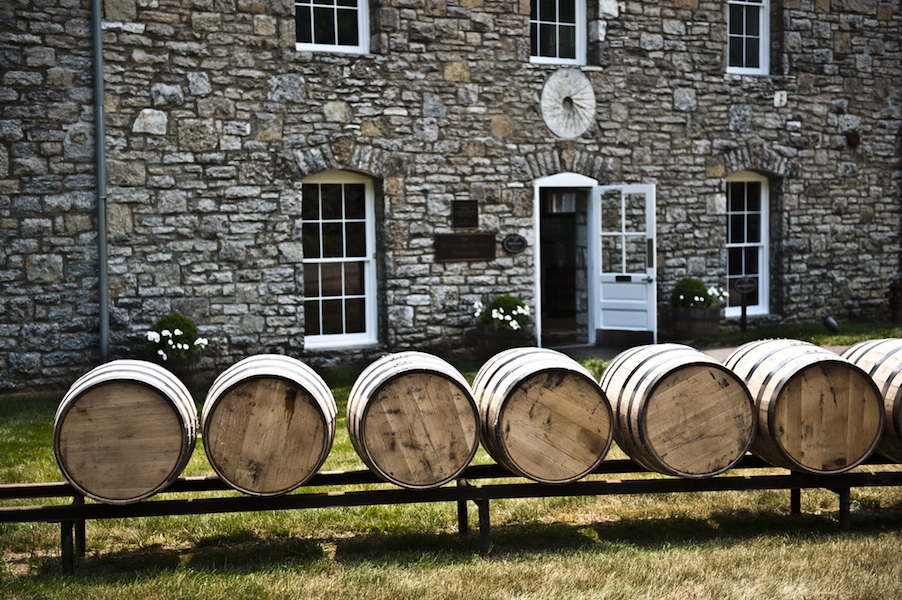 bourbon academy: rail with barrels on it in front of a stone building