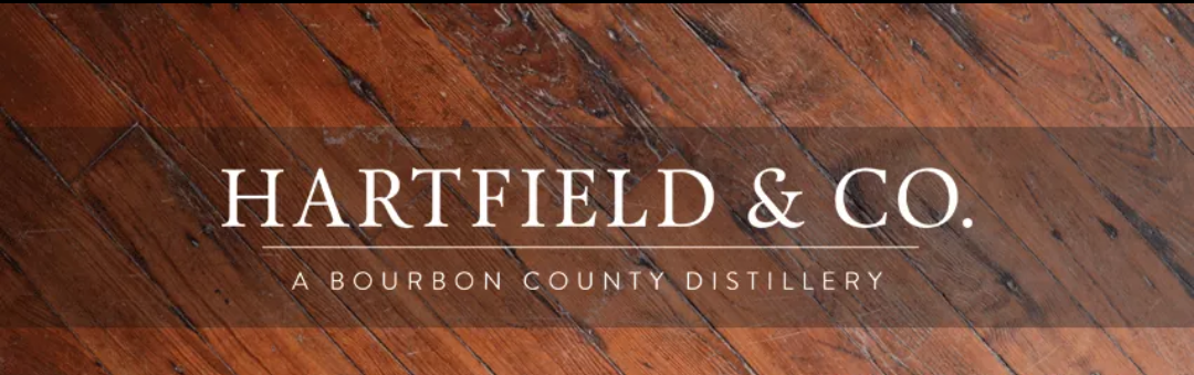 hartfield and co logo with wood in the background