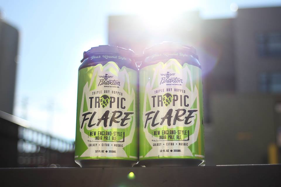 two green cans outside with the sun in the background that say "tropic flare"