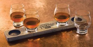 honored: wooden bourbon flight with kentucky bourbon trai branded in the middle