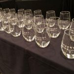 row of steamless wine glasses on a table with a black tablecloth