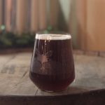 somerset: glass of a dark beer on a barrel
