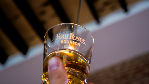 person holding a glass that says four roses