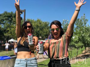 Forecastle: two girls with their hands up holding a truly