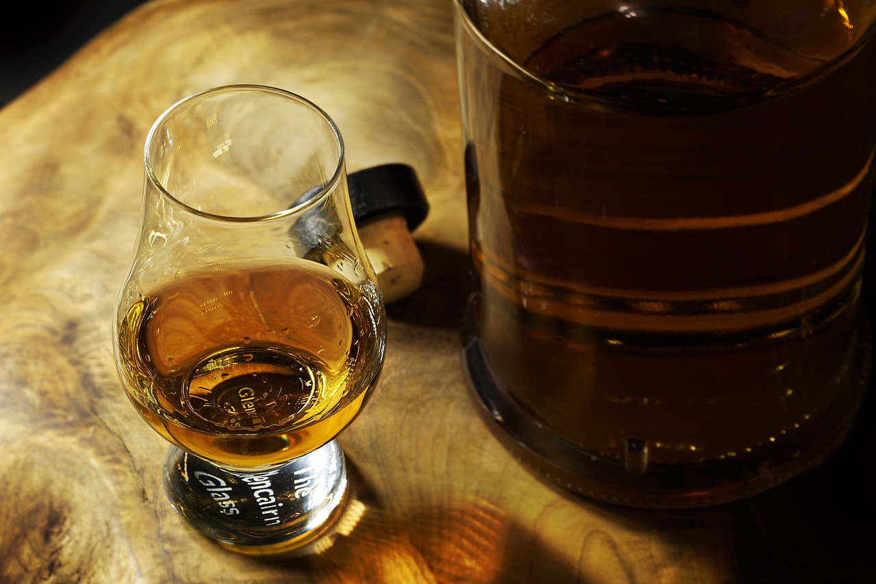 bourbon bar: bourbon in a glass and a bottle on a wooden table
